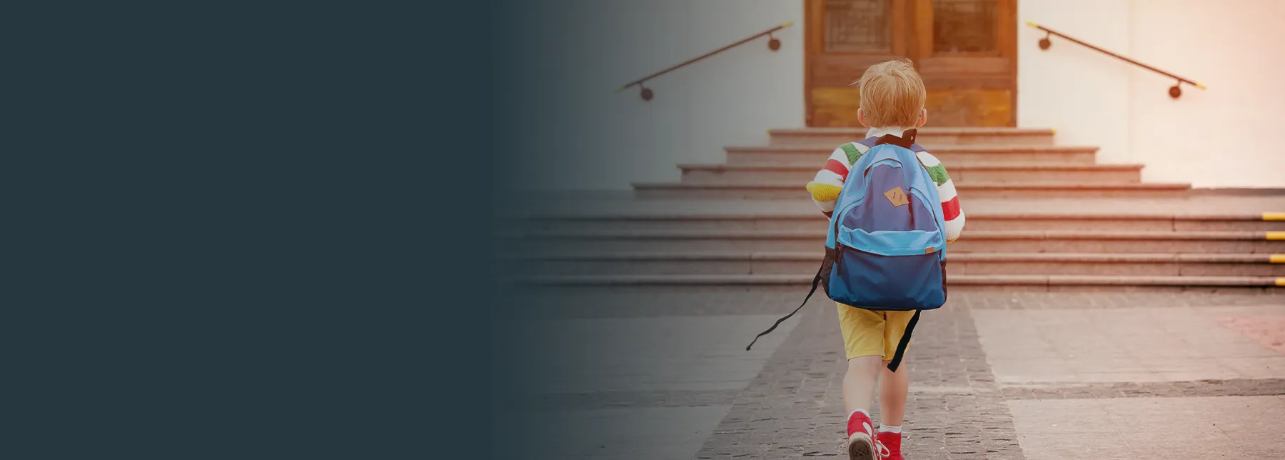 A small child wearing a blue backpack walks toward stone steps leading to a building entrance. The child is seen from behind, and a dark gradient overlay fills the left side of the image